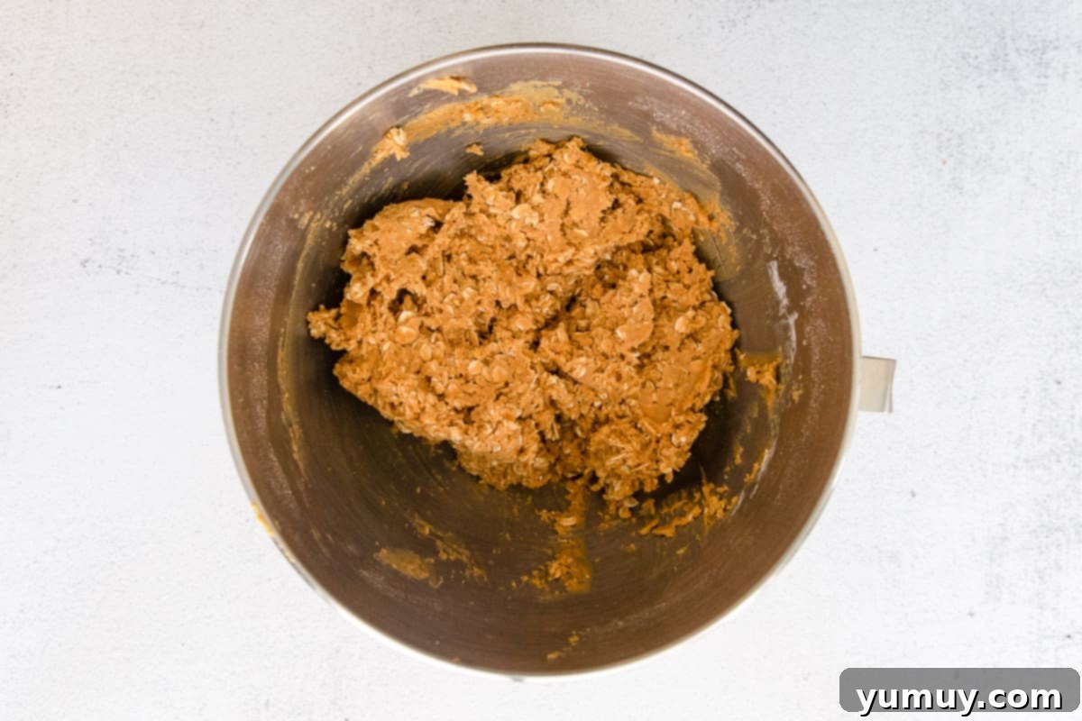 Spooktacular Monster Cookies 12 Peanut butter and oat dough mixture in a mixing bowl.