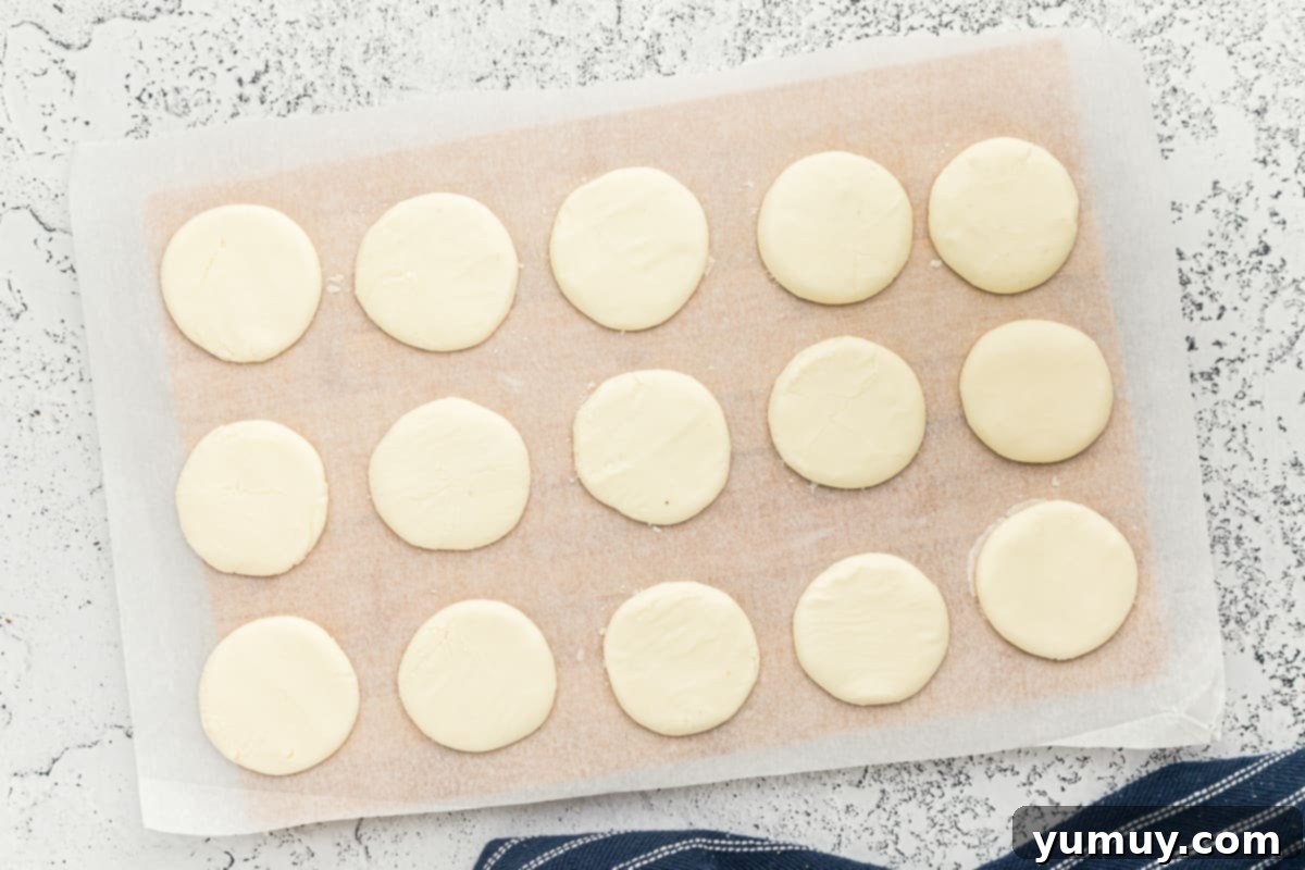 Rows of freshly shaped peppermint patties resting on parchment paper, drying before their chocolate coating.
