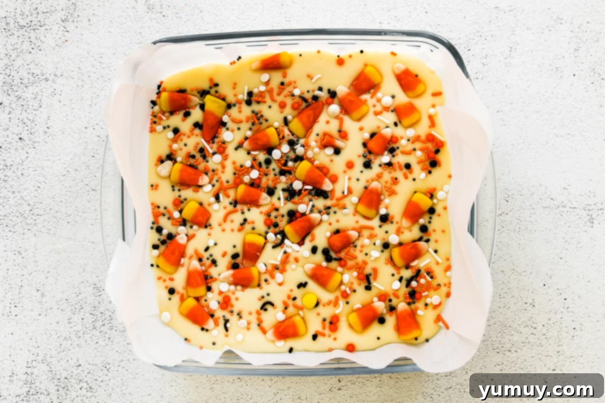 Haunted Fudge Delights 12 The completed Halloween fudge, vibrant with candy corn and various Halloween sprinkles, neatly arranged in a square pan.