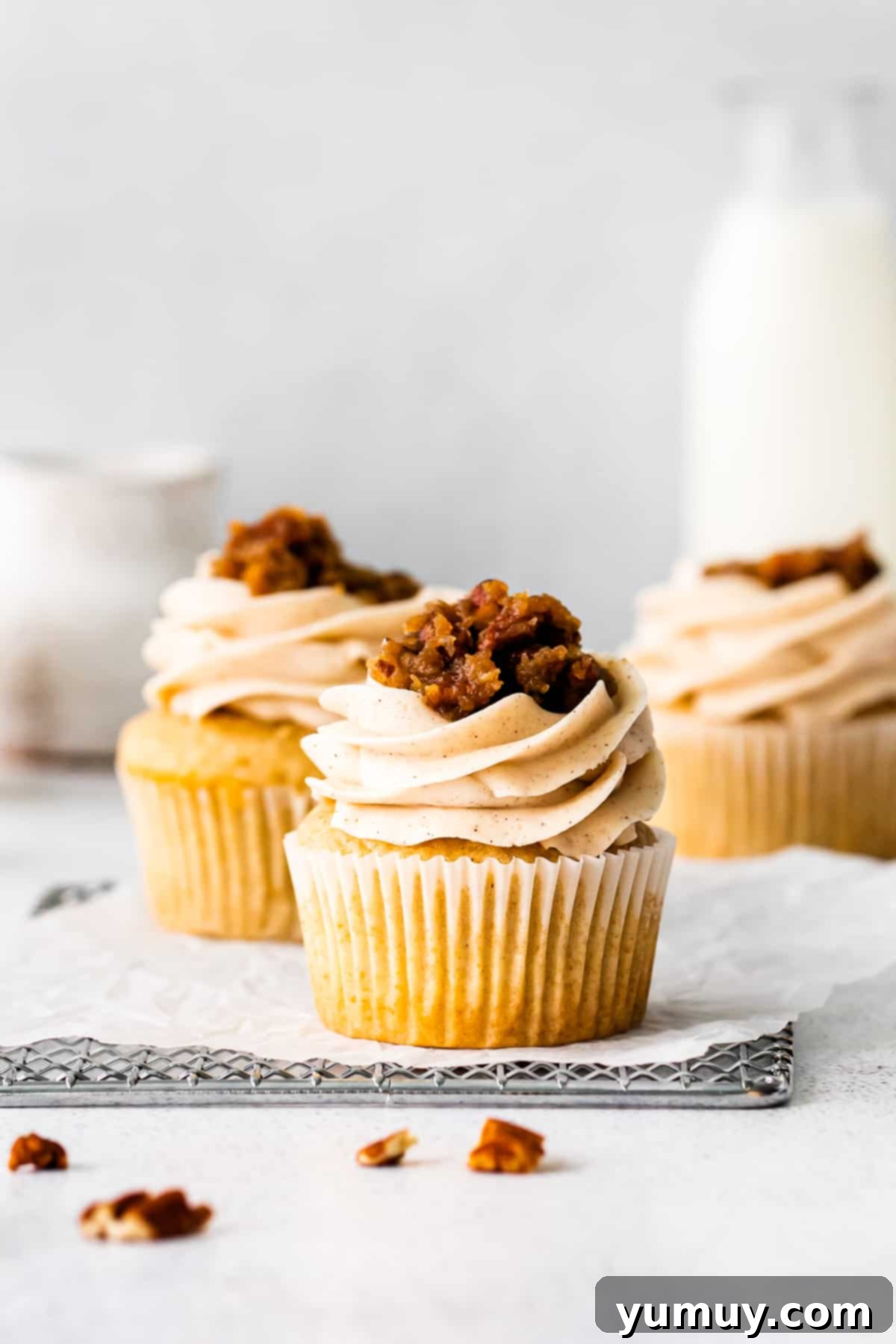 Pecan pie cupcakes topped with frosting and pecan pie filling