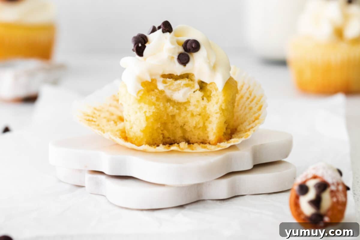 Cannoli Dream Cupcakes 14 A close-up of a beautifully assembled cannoli cupcake, showing the frosting and filling after a bite.