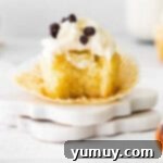 Cannoli Dream Cupcakes 9 A finished cannoli cupcake with a bite taken, revealing the rich filling and elegant frosting.