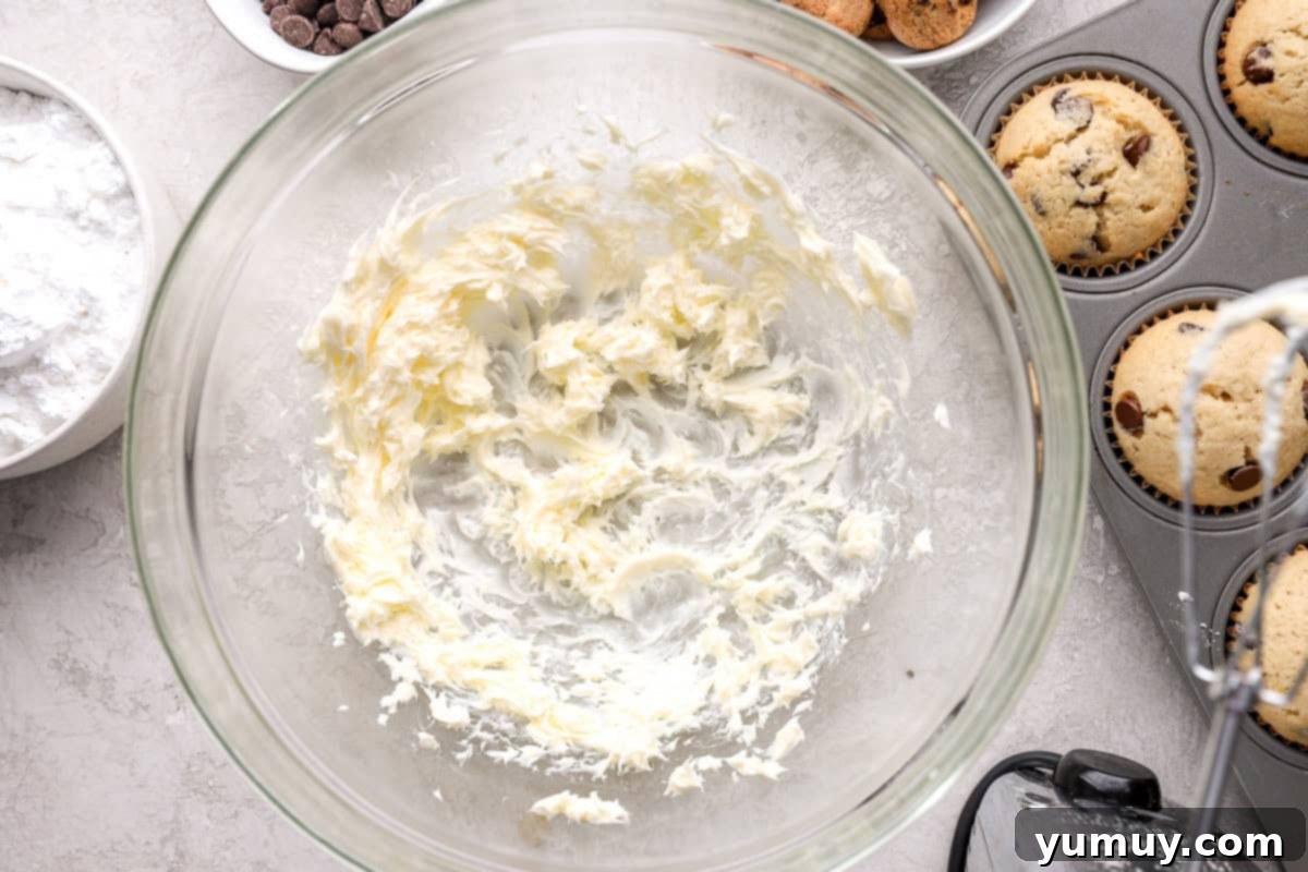 Ultimate Chocolate Chip Cupcakes 12 Expertly creamed unsalted butter, softened to perfection, whipped into a light and fluffy consistency within a glass mixing bowl.
