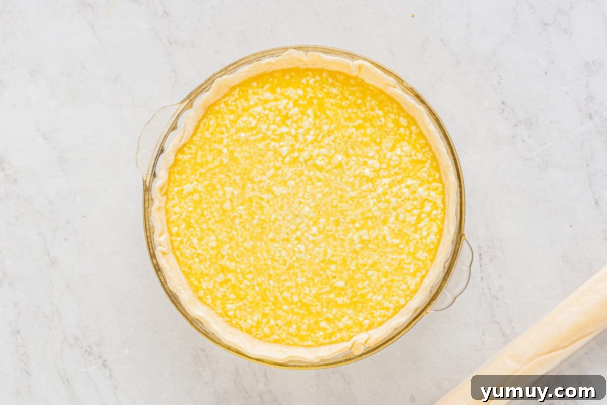 buttermilk chess pie filling poured into a pie crust lined pie dish