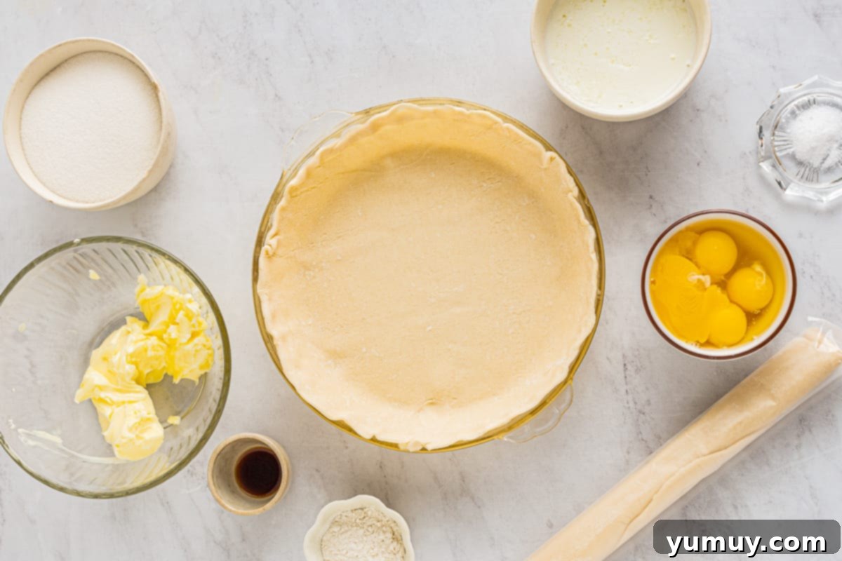 pie dough placed into a glass pie dish with ingredients in bowls, ready for baking