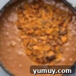Butterfinger Bliss Fudge 7 Stirring chopped Butterfinger candy pieces into the rich fudge mixture