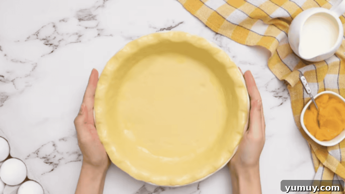 an egg washed raw pie crust in a pie pan.