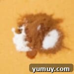 adding cornstarch, pumpkin pie spice, and salt to pumpkin pie filling in a glass bowl.