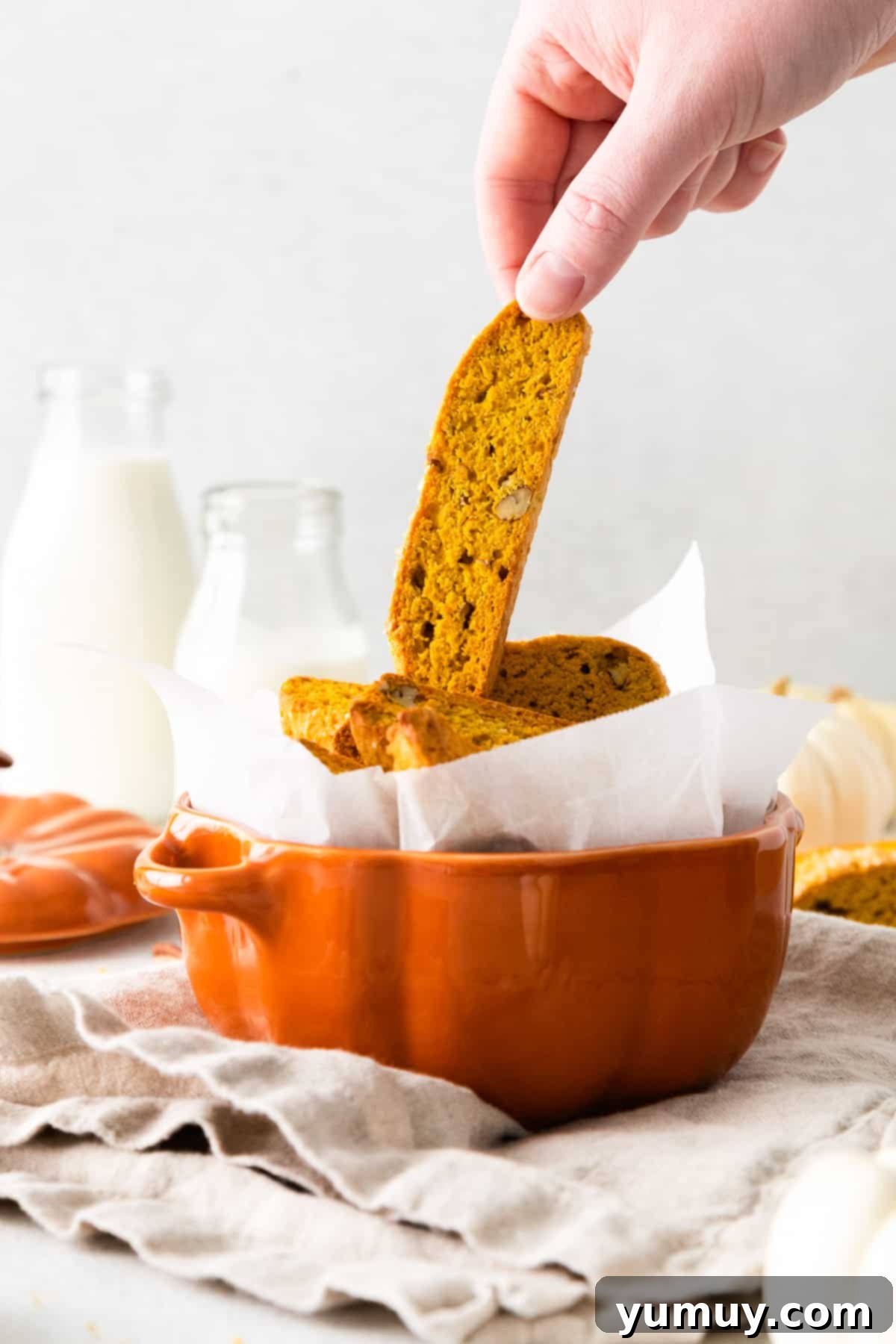 hand grabbing pumpkin pecan biscotti