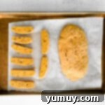 pumpkin pecan biscotti dough after baking on a baking sheet with one loaf cut into slices