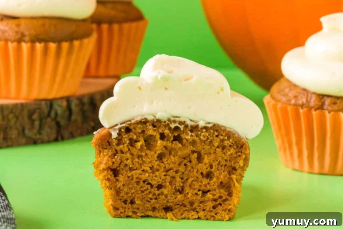 An inviting side view of a halved cake mix pumpkin cupcake, showcasing its perfectly baked, soft, and moist texture that promises a delightful culinary experience.