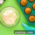 cream cheese frosting in a clear bowl with a piping bag