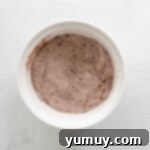 Dry ingredients for chocolate pumpkin cupcakes mixed in a white bowl.