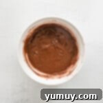 Chocolate pumpkin cupcake batter in a white mixing bowl, perfectly combined.