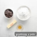 Overhead view of chocolate pumpkin cupcake frosting ingredients, including softened butter, in a mixing bowl.