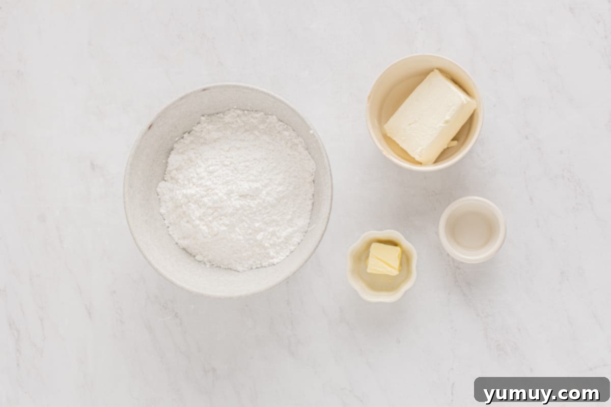 A flat lay photograph showcasing the simple ingredients for Christmas cream cheese mints: powdered sugar, cream cheese, butter, peppermint extract, and red and green food coloring.