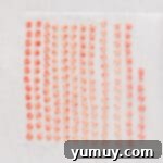 red and white cream cheese mints piped onto parchment paper