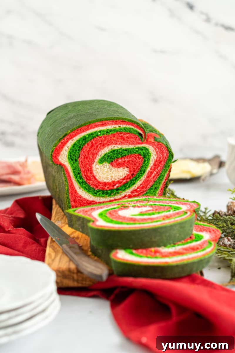 Sliced Christmas swirl bread showing the vibrant red and green pattern inside