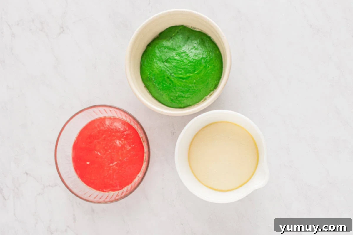 Three distinct balls of dough: natural, red, and green, each in a bowl and covered, rising