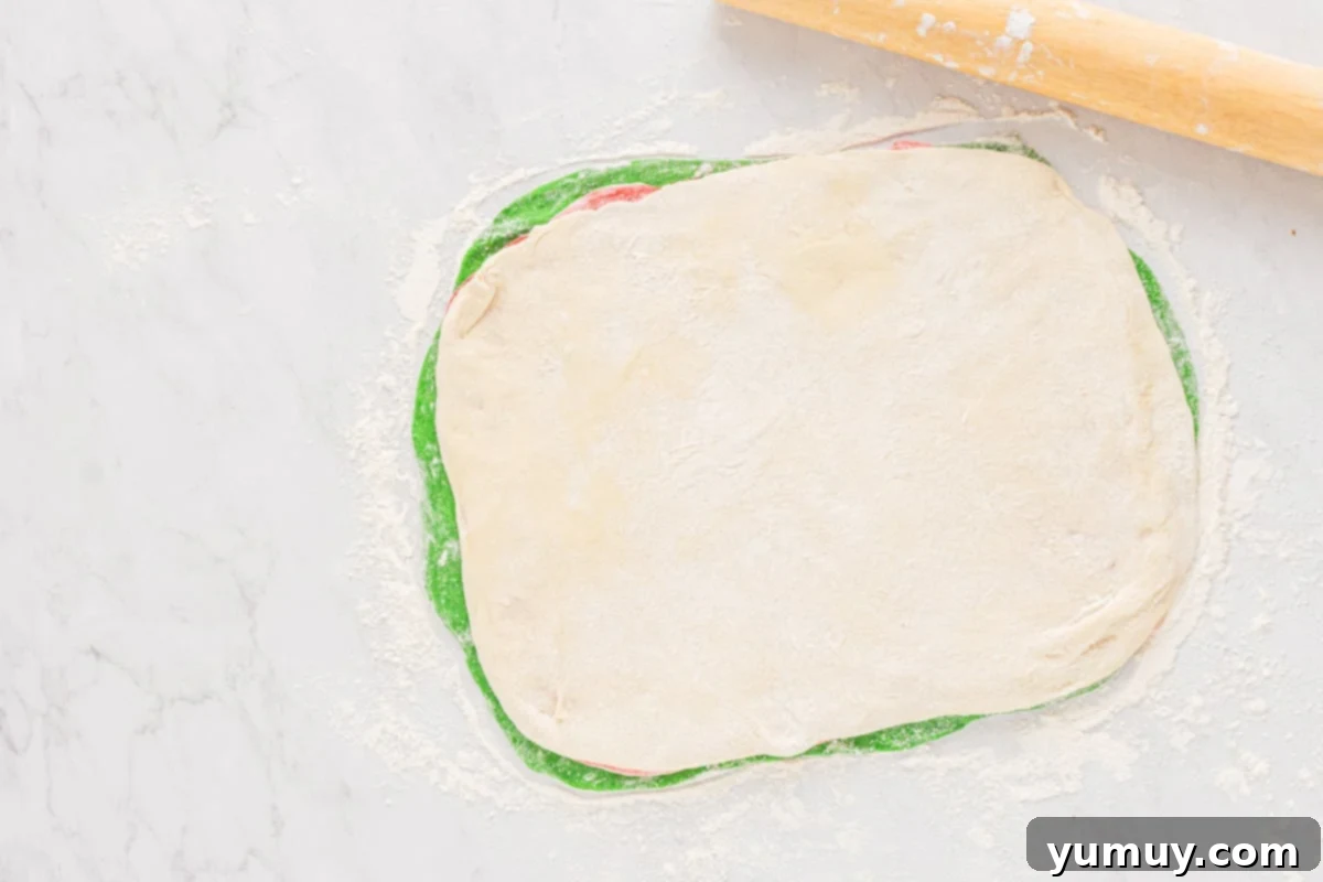 Red, white, and green dough layers stacked neatly, ready to be rolled into a loaf