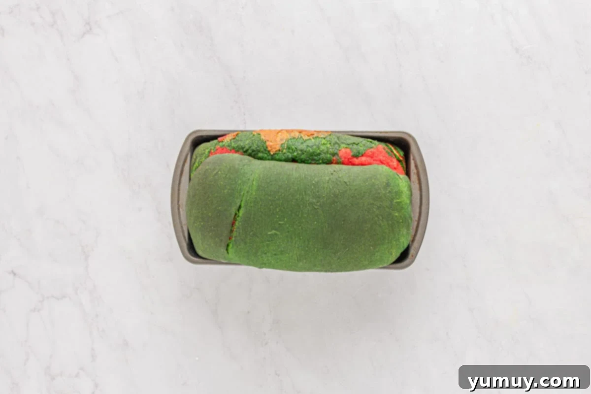 Freshly baked Christmas swirl bread, golden brown and cooling on a wire rack in its pan