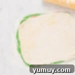 Layered sheets of red, white, and green dough, ready for rolling