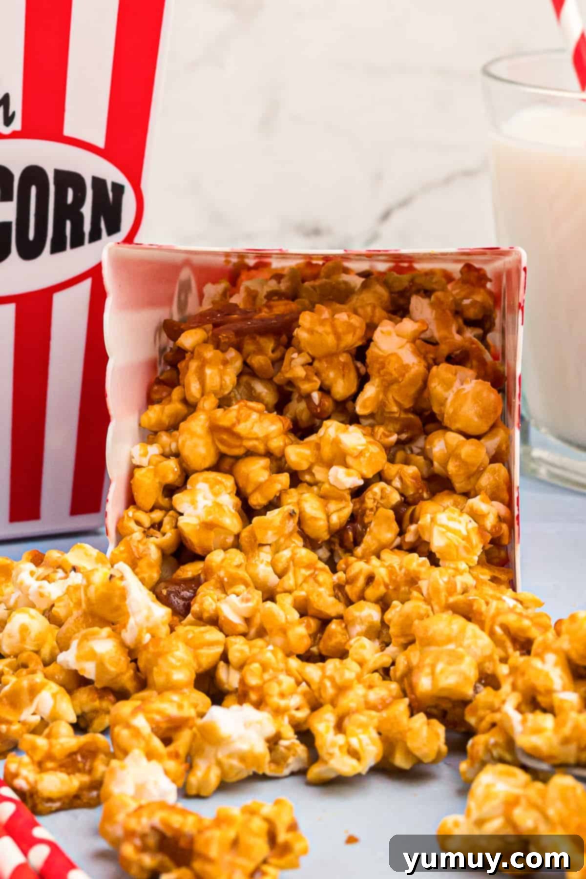 Golden Caramel Crunch 3 caramel corn spilling out of a movie theater popcorn box.