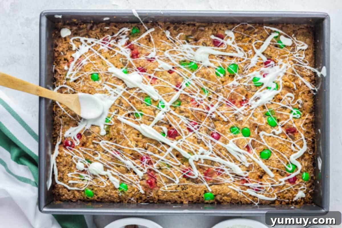 drizzling white chocolate onto magic cookie bars in a baking pan