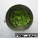 Green colored cookie dough in a mixing bowl.