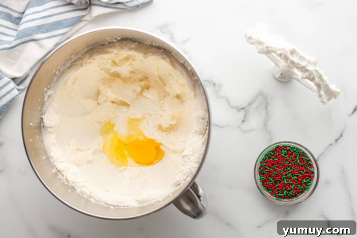 adding eggs to sugar cookie dough in a bowl