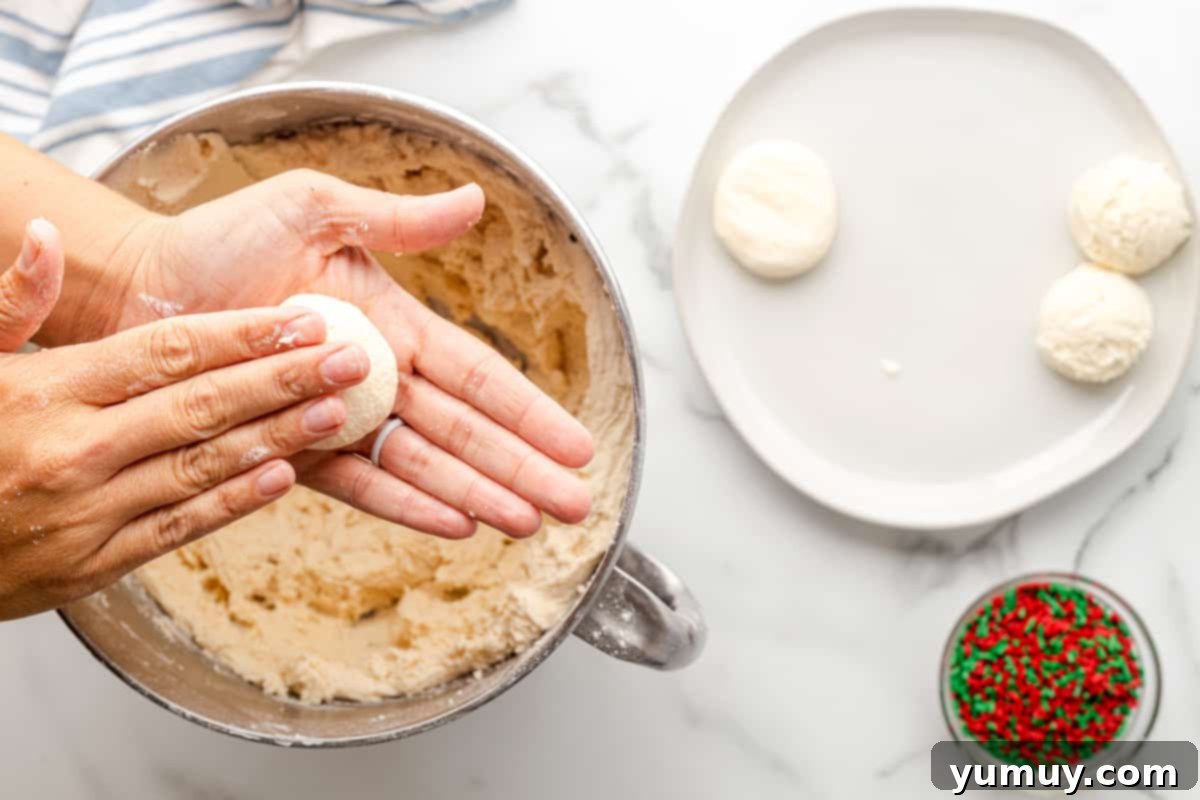 hands flattening sugar cookie dough balls