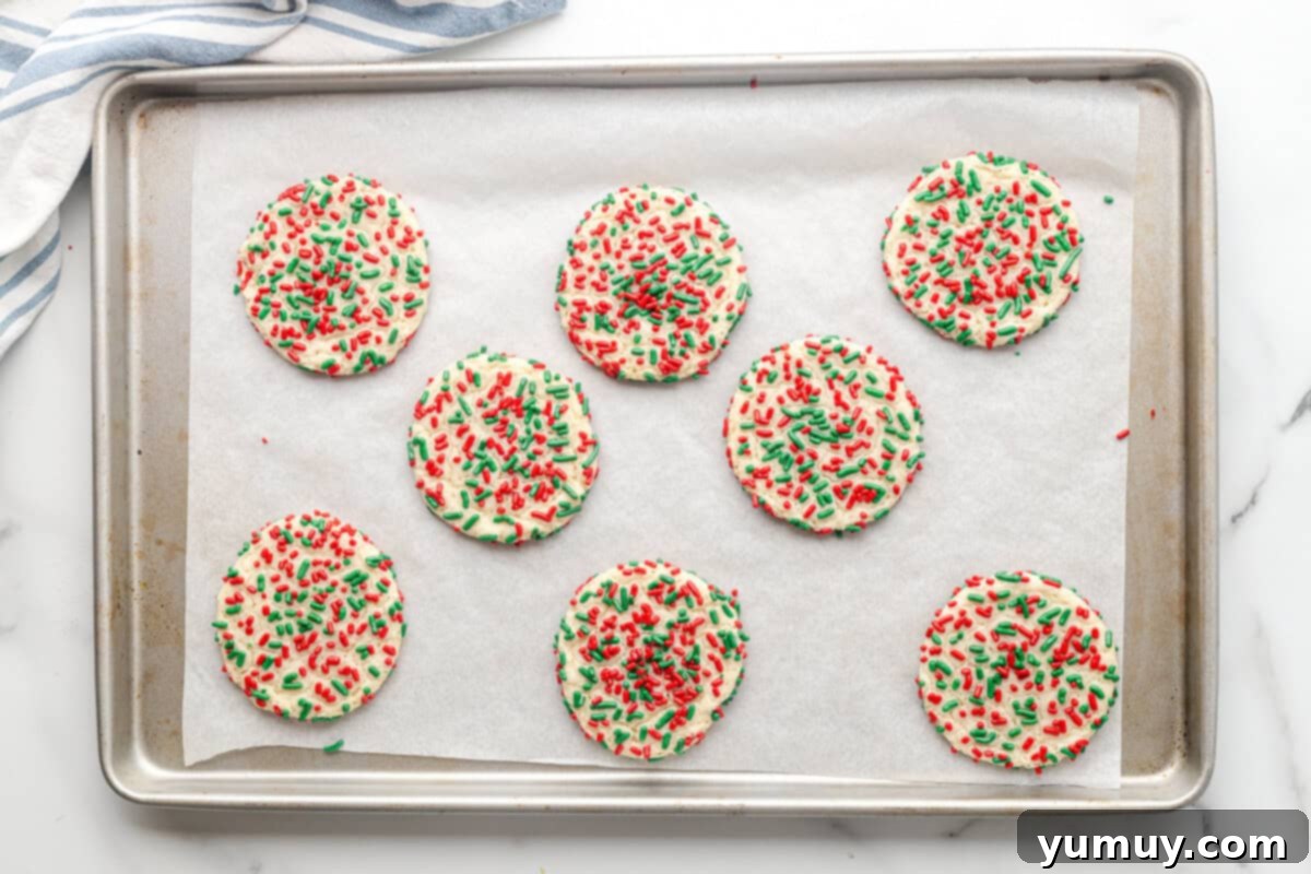 sugar cookies with red and green sprinkles on a baking sheet after baking