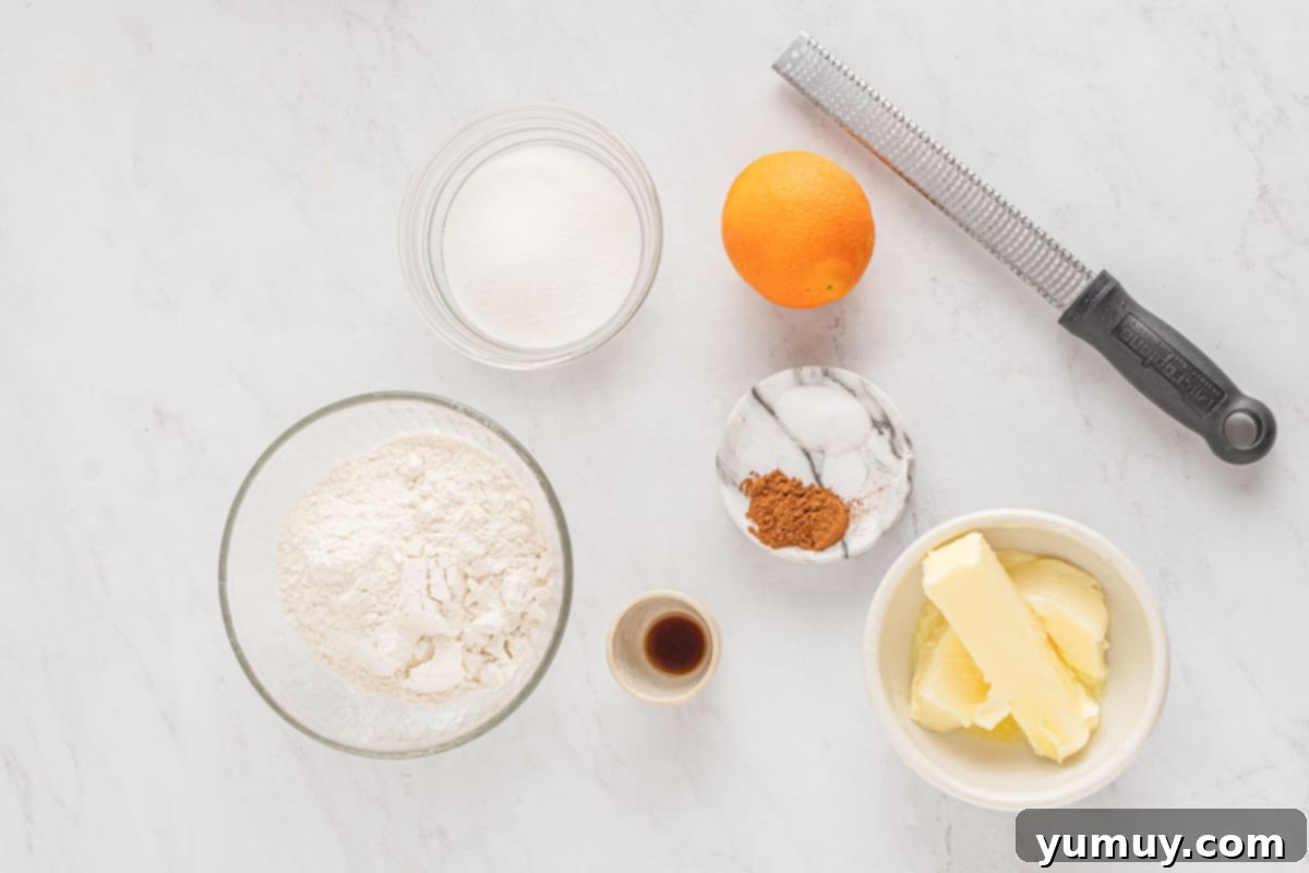 Holiday Wreath Delights 3 A selection of fresh, high-quality ingredients laid out for shortbread wreath cookies, including butter, flour, sugar, and a vibrant orange with a zester.