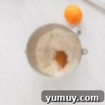 Holiday Wreath Delights 7 Dry ingredients like flour, salt, and cinnamon being added to the mixing bowl alongside an orange and zester.