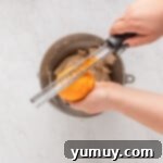 Holiday Wreath Delights 8 Fresh orange zest being added to the cookie dough in a mixing bowl.