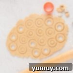 Holiday Wreath Delights 9 Cutting wreath shapes out of rolled cookie dough using a circular cutter and a smaller tool for the center.