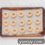 Holiday Wreath Delights 10 Shortbread cookies neatly lined up on a parchment-lined baking sheet, freshly baked.