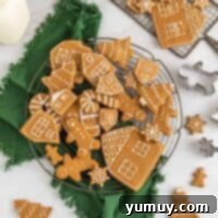 Festive Gingerbread Treats 5 Overhead view of beautifully iced gingerbread cookies on a round wire cooling rack, glistening with festive decorations.