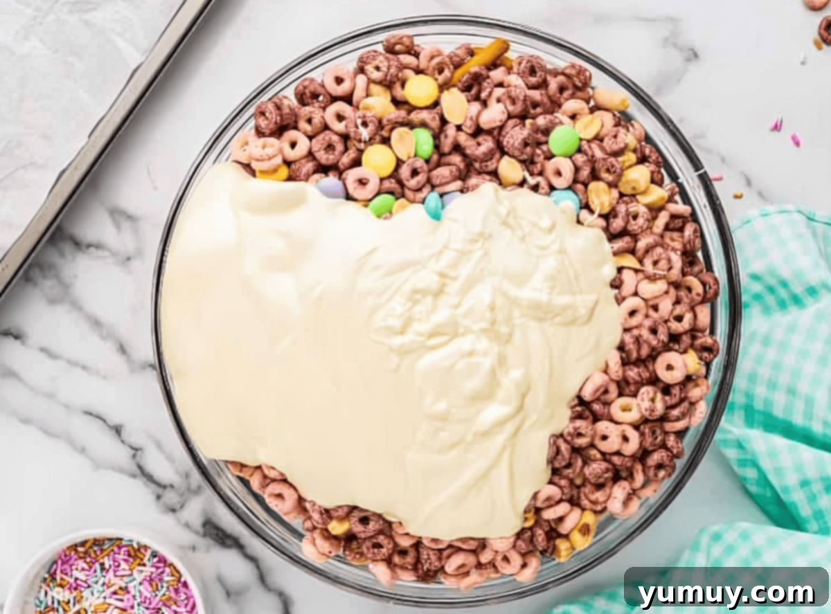 melted white chocolate poured over bunny bait ingredients in a glass bowl.