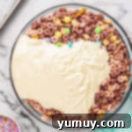 melted white chocolate poured over bunny bait ingredients in a glass bowl.