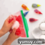 smushing red dyed rice around a hard boiled egg in a ziplock bag.