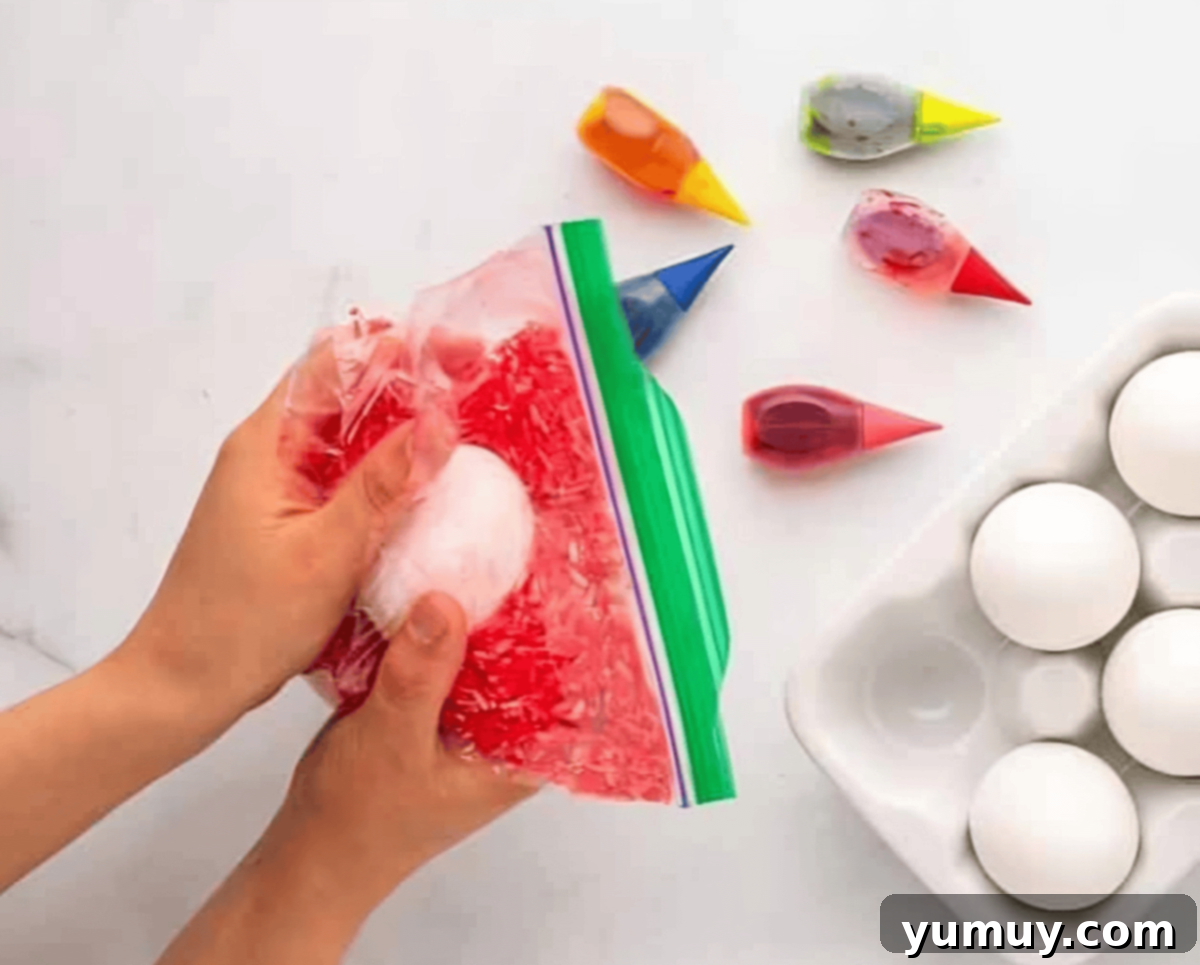 smushing red dyed rice around a hard boiled egg in a ziplock bag.