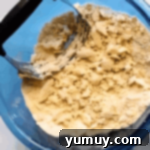 Luscious Raspberry Bars 6 Crumbly dough mixture in a blue glass bowl with a pastry cutter.