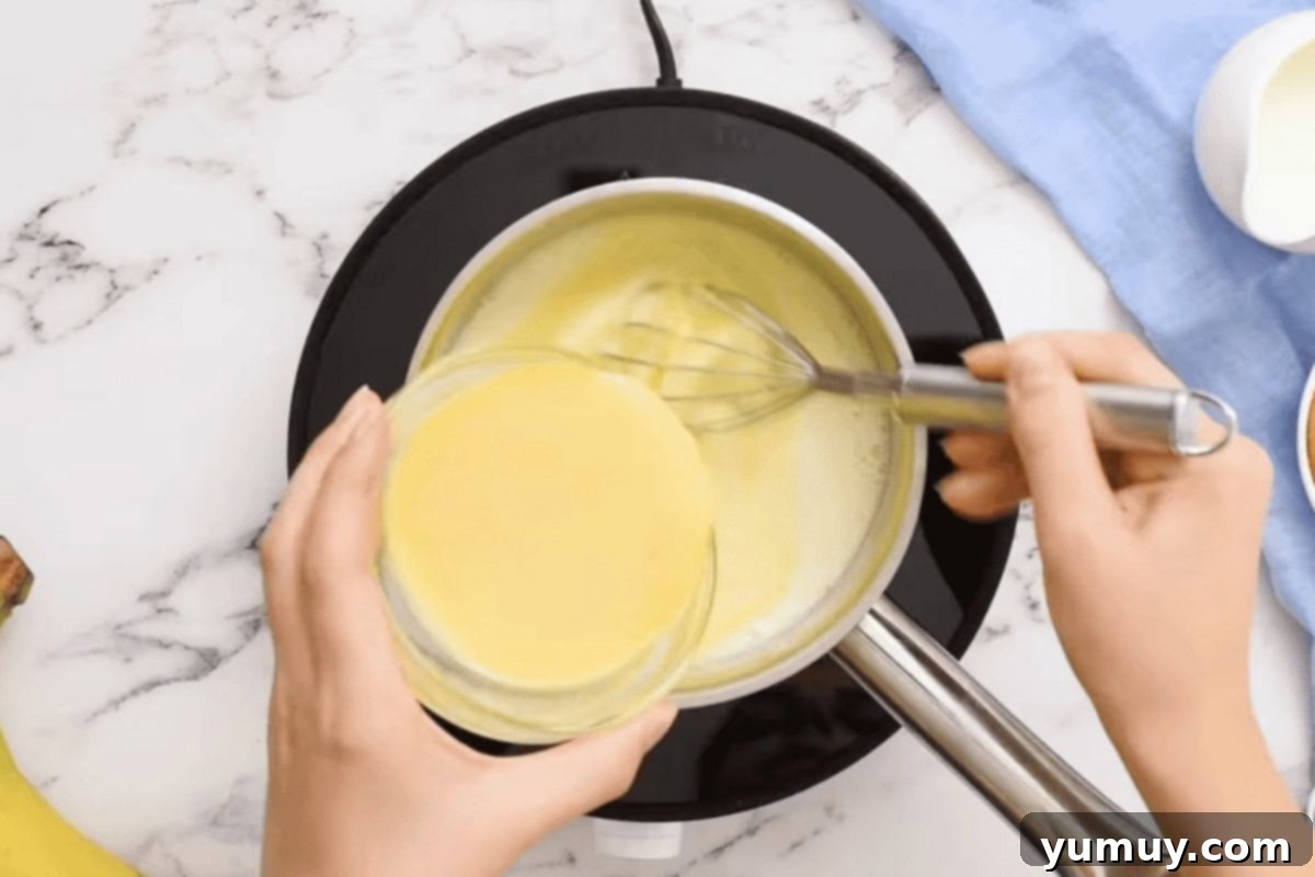 pouring tempered eggs into warm milk in a saucepan.