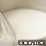 whisking flour, sugar, and milk in a saucepan.