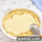 spreading pudding over banana slices in a baking dish.