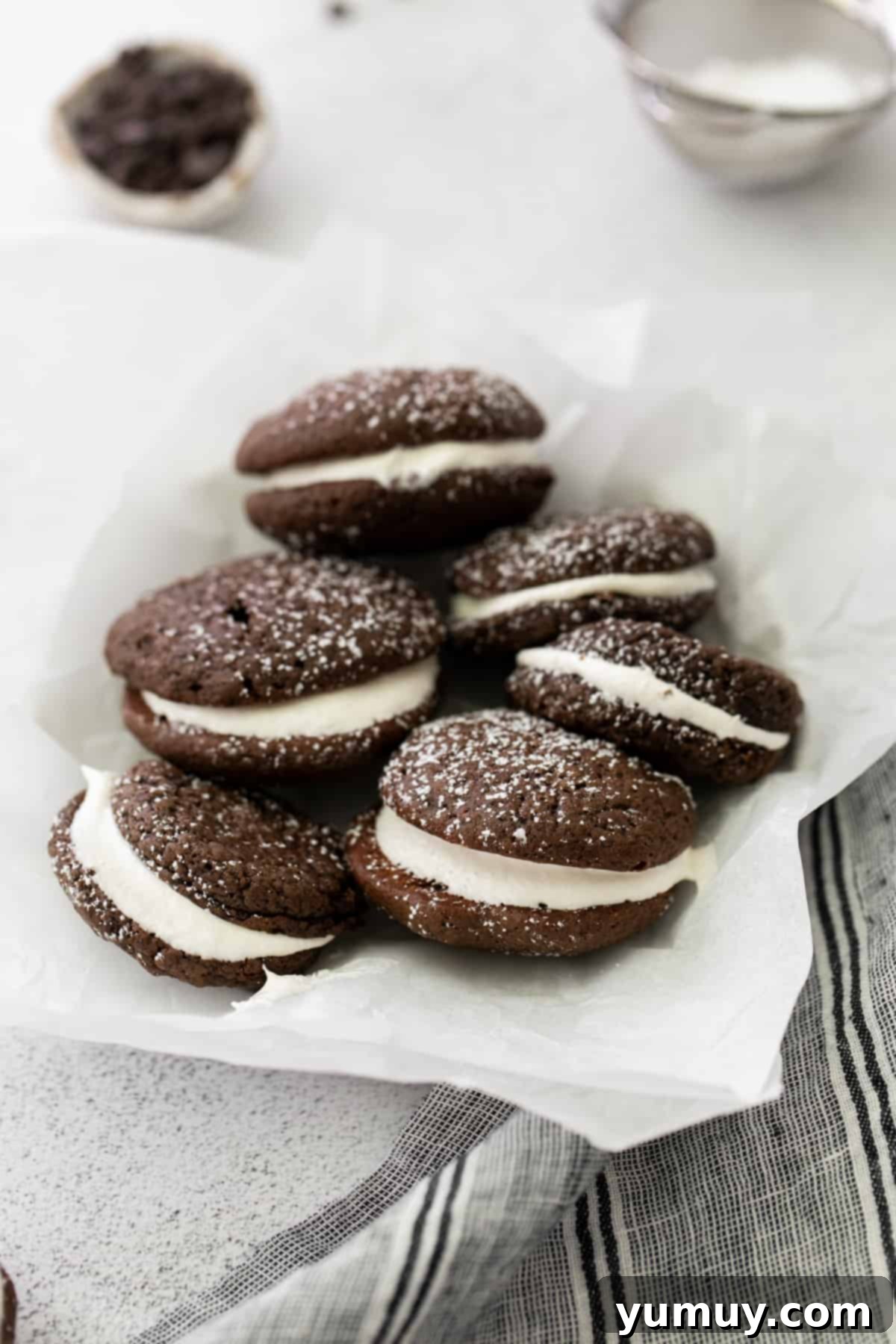 Beautifully arranged chocolate whoopie pies on parchment paper, showcasing their perfect round shape and rich color.