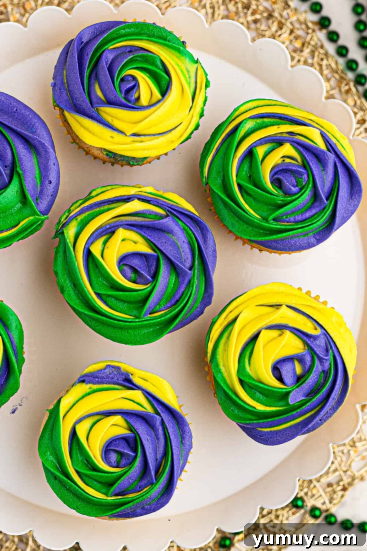 Overhead view of beautifully decorated Mardi Gras cupcakes, showcasing the festive tri-color frosting.