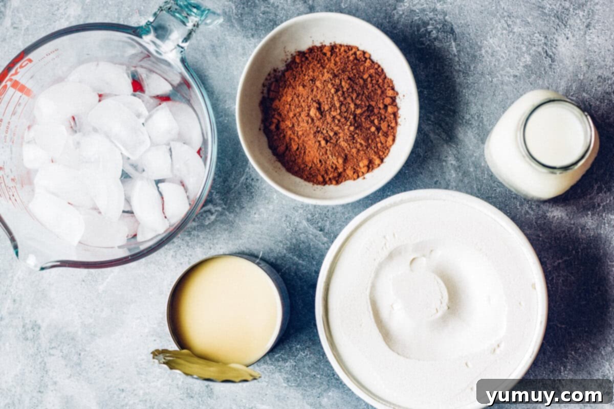 Make Your Own Wendy's Chocolate Frosty at Home 4 All ingredients for a copycat chocolate frosty recipe laid out on a counter: frozen whipped topping, sweetened condensed milk, cocoa powder, milk, and ice cubes.