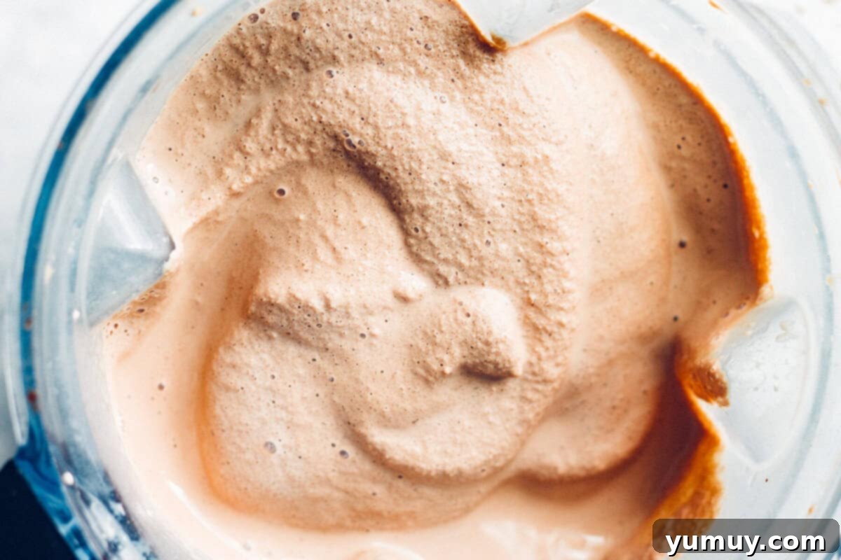 Make Your Own Wendy's Chocolate Frosty at Home 6 Close-up of the thick, blended chocolate frosty mixture swirling in a high-powered blender.